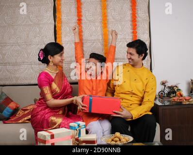 Couple donnant des cadeaux à leur fils au festival Diwali. Banque D'Images