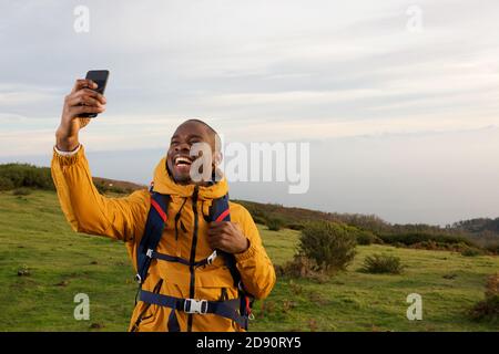 Portrait d'un heureux routard afro-américain prenant le selfie dans la nature Banque D'Images