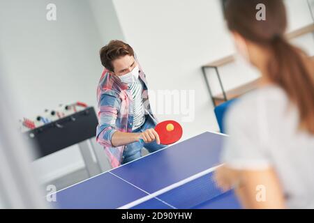 Deux étudiants portant un masque tout en jouant au tennis de table le campus Banque D'Images