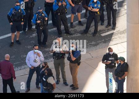 Austin, TX USA 30OCT20: La police d'Austin et les gendarmes du comté de Travis gardent le regard tandis que les partisans de Donald Trump bloquent un bus de campagne Biden-Harris dans le parking du bureau AFL-CIO. Les supporters ont suivi le bus de San Antonio sur une route bondée à Austin. Les passagers de l'autobus ont appelé la police lorsque certains des camions de pick-up des partisans de Trump ont encerclé l'autobus et, ont-ils dit, ont tenté de le faire sortir de la route. Plusieurs événements démocrates ont été annulés en raison de ces perturbations. Le FBI enquête sur l'incident. Banque D'Images