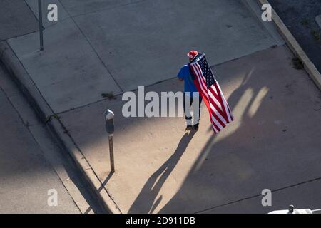 Austin, TX USA 30OCT20: Un partisan de Trump avec un drapeau américain et un drapeau du Texas modifié avec une feuille de marijuana à la place des défilés Lone Star tandis que d'autres bloquent un bus de campagne Biden-Harris au bureau AFL-CIO dans le centre-ville d'Austin. Le bus est arrivé à Austin à la suite d'un incident de circulation sur une autoroute bondée pendant qu'il voyageait de San Antonio. Les partisans de Biden à bord de l'autobus ont réclamé une douzaine de pick-up affiliés à Trump qui ont tenté de faire descendre l'autobus de la route. Plusieurs événements démocrates ont été annulés en raison de ces perturbations. Le FBI enquête sur l'incident. Banque D'Images