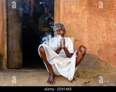 Purulia, Bengale-Occidental / Inde - novembre 01,2020. Un vieil homme non identifié prenant Hookah à l'extérieur de sa maison de boue. Banque D'Images