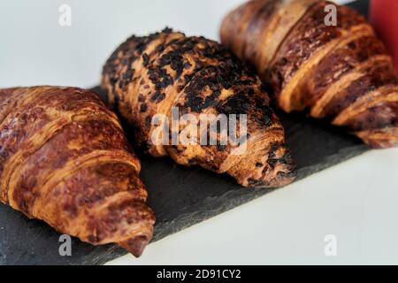 trois croissants sur un plateau noir vue sur le dessus Banque D'Images