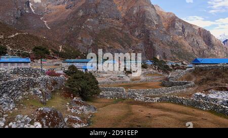 Maisons en pierre avec des toits peints en bleu et des prairies entourées de murs de pierre dans le petit village de Thame, Khumbu, Himalaya, Népal sur les trois cols Trek. Banque D'Images