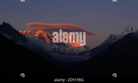 Vue panoramique spectaculaire sur les montagnes majestueuses de l'Everest, Nuptse, Lhotse et Ama Dablam avec des sommets illuminés rouges au coucher du soleil depuis un point de vue. Banque D'Images