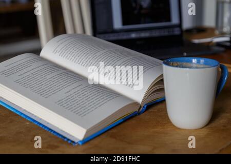 Multitâche lecture boire du café sur un ordinateur portable Banque D'Images