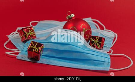 Masques avec décorations de Noël sur fond rouge Banque D'Images