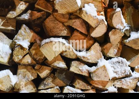 pile de bois de chauffage haché à l'extérieur par temps hivernal enneigé Banque D'Images