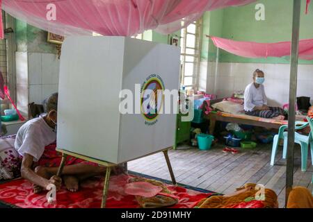 Une femme âgée lance son bulletin de vote dans une maison de soins infirmiers pendant le vote par anticipation pour les personnes âgées à Mandalay. Banque D'Images