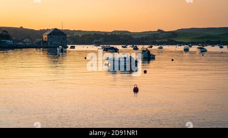 Rock Sailing et ski nautique Clubhouse à l'aube avec le lever du soleil se reflète sur l'eau calme avec des bateaux à l'aube. Banque D'Images