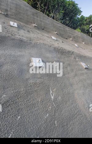 Protection contre la chute des maillons de chaîne revêtue de ciment avec des ancrages visibles à la surface. Travaux de stabilisation effectués dans la ville de Lostwithiel, en Cornouailles. Banque D'Images