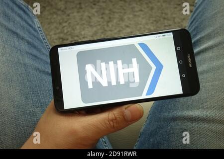 Homme portant un smartphone portant le logo des National Institutes of Health Banque D'Images