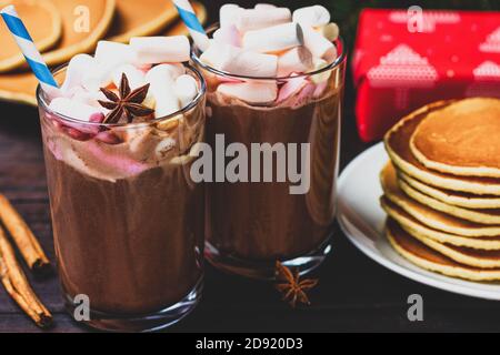 Deux verres de chocolat chaud avec guimauves, étoile anisée et crêpes sur le fond de la padarka de Noël du nouvel an Banque D'Images