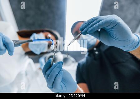 Hommes et femmes dentistes travaillant ensemble au bureau. Vue première personne Banque D'Images