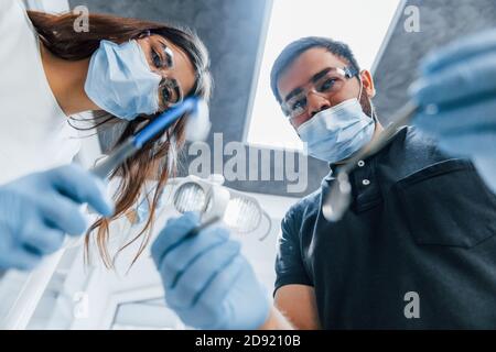 Hommes et femmes dentistes travaillant ensemble au bureau. Vue première personne Banque D'Images