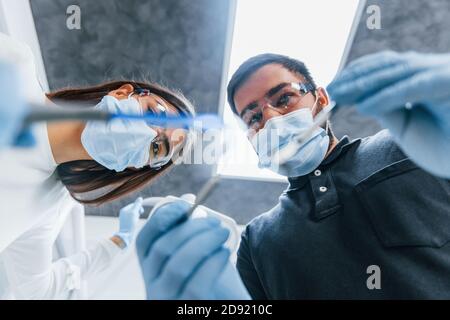Hommes et femmes dentistes travaillant ensemble au bureau. Vue première personne Banque D'Images
