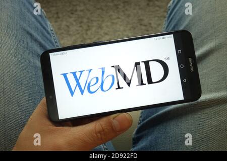 Homme tenant un smartphone avec le logo de la société WebMD Health Corp Banque D'Images