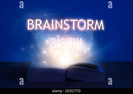 Livre ouvert avec inscription de remue-méninges. Lumière provenant d'un livre ouvert avec brainstorming de mot. Banque D'Images
