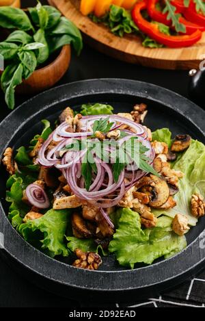 Salade géorgienne avec viande sur fond noir Banque D'Images