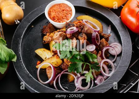 Salade géorgienne avec viande sur fond noir Banque D'Images