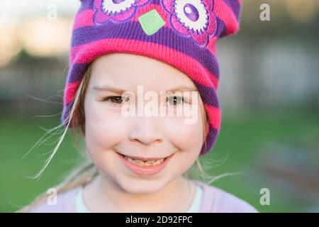 Gros plan d'une jeune fille souriant et portant un haut en couleur chapeau Banque D'Images