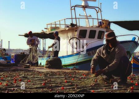 Marsaxlokk, Malte - 07 2017 mai - les pêcheurs collectent et nettoient les filets de pêche après la prise fraîche de la journée Banque D'Images