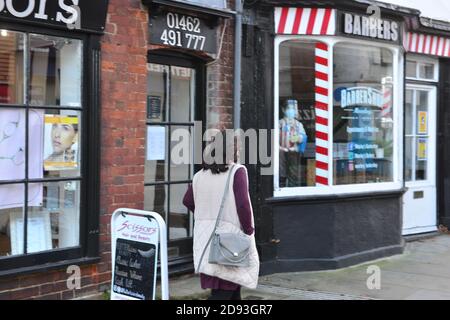 Hertfordshire, royaume-uni, 01-11-2020, façade de magasin de détail du salon de coiffure avec salon de coiffure juste à côté et une femme passant devant Banque D'Images