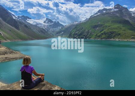 Fille assise sur le rocher et appréciant la belle vue de haut lac de montagne près de Kaprun.calme détente dans la nature.magnifique paysage de la nature, turquoise wat Banque D'Images