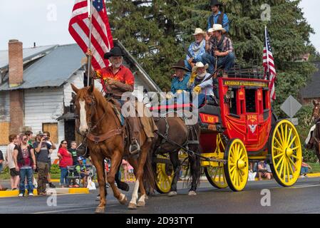 Une calèche de la vieille journée portant le drapeau américain au Grand Parade pendant le Stampede d'Omak, État de Washington, États-Unis Banque D'Images