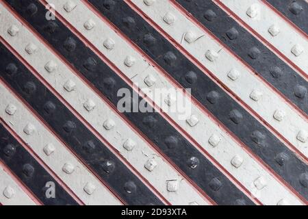 La grille est peinte avec des bandes noires et blanches alternées. Banque D'Images