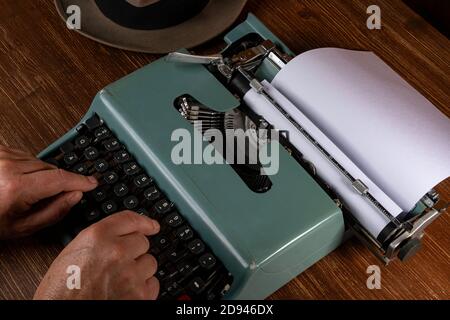 un homme tout en écrivant avec une vieille machine à écrire Banque D'Images