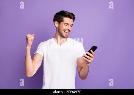 Portrait de son beau beau attrayant gai gai gai gars heureux utiliser un appareil numérique pour célébrer comme avoir des bonnes nouvelles amusantes isolées sur vif vif vif Banque D'Images