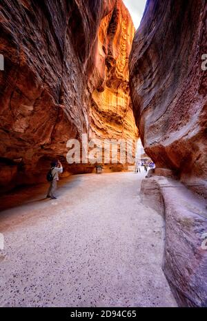 Les touristes se promènant dans le canyon Al Siq entre l'entrée de l'ancienne ville jordanienne de Pétra et le temple Al-Khazneh, également connu sous le nom de Trésor Banque D'Images