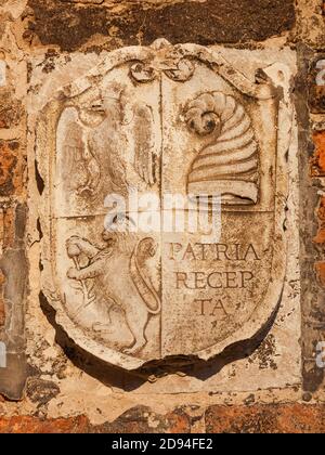 Ancien emblème héraldique avec aigle impérial, chapeau de doge (corne) et lion sur un mur de Venise Banque D'Images