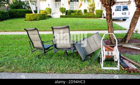 Les déchets en vrac, y compris les chaises jetées sur le trottoir pour la collecte des déchets. Banque D'Images