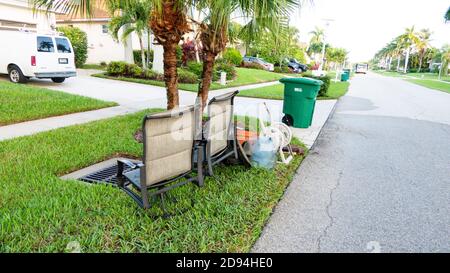Les déchets en vrac, y compris les chaises jetées sur le trottoir pour la collecte des déchets. Banque D'Images