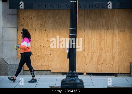 Washington DC, États-Unis, 2 novembre 2020. Un piéton passant par un front de vente embarqué révélant une vue dystopique sur le Capitole de la nation un jour avant le Banque D'Images