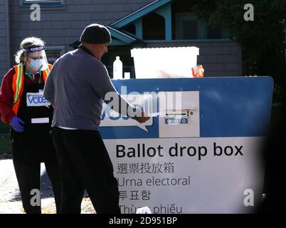 Seattle, Washington, États-Unis. 2 novembre 2020. Diane Pavelin (à gauche), travailleuse aux élections du comté de King, aide un électeur à une boîte de dépôt des bulletins de vote à la bibliothèque Beacon Hill à Seattle, Washington, le 2 novembre 2020. L'État de Washington s'attend à une participation record des électeurs pour cette élection. Crédit : Karen Ducey/ZUMA Wire/Alay Live News Banque D'Images