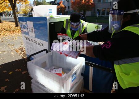 Seattle, Washington, États-Unis. 2 novembre 2020. Ebony Tucker (à droite) et Susan Rost (à gauche), pilotes pour les élections du comté de King, ont vidé une boîte de dépôt des bulletins de vote à la bibliothèque Beacon Hill à Seattle, Washington, le 2 novembre 2020. L'État de Washington s'attend à une participation record des électeurs pour cette élection. Crédit : Karen Ducey/ZUMA Wire/Alay Live News Banque D'Images