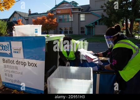 Seattle, Washington, États-Unis. 2 novembre 2020. Ebony Tucker (à droite) et Susan Rost (à gauche), pilotes pour les élections du comté de King, ont vidé une boîte de dépôt à la bibliothèque Beacon Hill à Seattle (Washington) le 2 novembre 2020. L'État de Washington s'attend à une participation record des électeurs pour cette élection. Crédit : Karen Ducey/ZUMA Wire/Alay Live News Banque D'Images