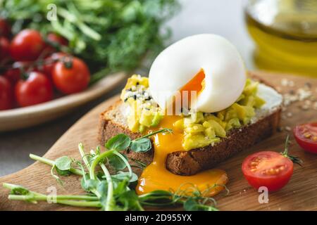 Toast avec avocat et œuf garni de graines de sésame. Déjeuner santé déjeuner ou en-cas Banque D'Images