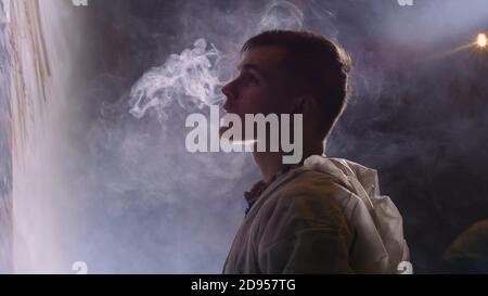 Concepteur de l'artiste dessine un aigle sur le mur. Décorateur artisan peint un tableau à l'acrylique couleur d'huile. Vaper fume vape. Magie noire cinematic look. Banque D'Images
