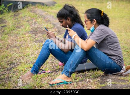 Deux jeunes filles s'affairent à regarder leur téléphone portable Banque D'Images