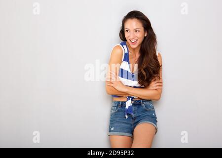 Portrait horizontal d'une femme asiatique heureuse en train de rire sur fond gris Banque D'Images