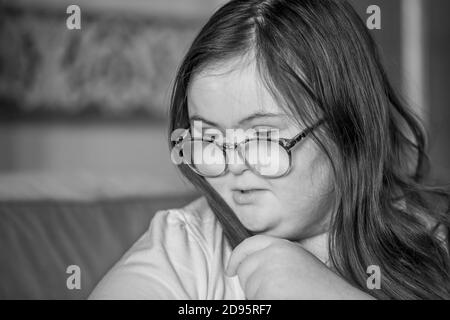 Jeune adolescente avec le syndrome de Downs se brossant les cheveux à l'intérieur, Northampton, Angleterre, Royaume-Uni. Banque D'Images