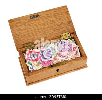 Petite boîte en bois remplie de vieux timbres-poste à franchies isolés sur fond blanc Banque D'Images