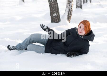 Adorable fille d'apparence nordique invite à jouer boules de neige en forêt. Banque D'Images