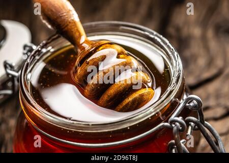 Pot de miel avec un balancier sur une table en bois - gros plan Banque D'Images