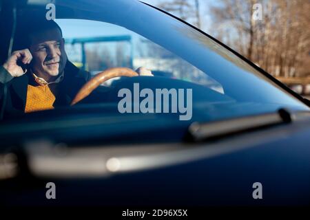 Russie Moscou 02 NOVEMBRE 2014 Homme parlant sur téléphone portable tout en conduisant sa voiture. Banque D'Images