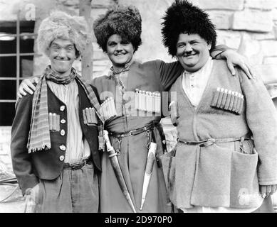 STAN LAUREL et OLIVER HARDY et LAWRENCE TIBBETT sur le set Candid pendant le tournage de LA CHANSON VOYOU 1930 réalisateurs LIONEL BARRYMORE et HAL ROACH Metro Goldwyn Mayer Banque D'Images